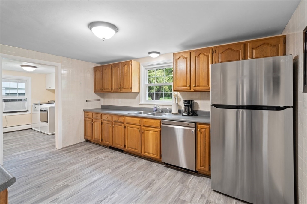 19 Hudson Road Oxford, MA 01540 - Photo 8 of 40 a kitchen with stainless steel appliances granite countertop a refrigerator a sink dishwasher a stove with wooden cabinets and wooden floor