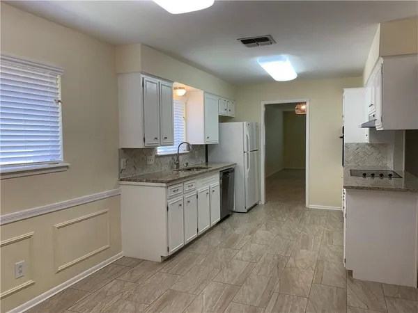 a kitchen with granite countertop a sink cabinets and stainless steel appliances