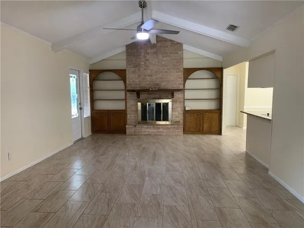 a view of a livingroom with wooden floor staircase and a kitchen space