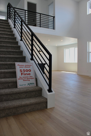 2613 Scarlet Road, Unit 258 Eagle Mountain, UT 84005 - Photo 6 of 32 Two-story foyer featuring a contemporary black metal baluster railing system, carpeted staircase, and wood-finish flooring