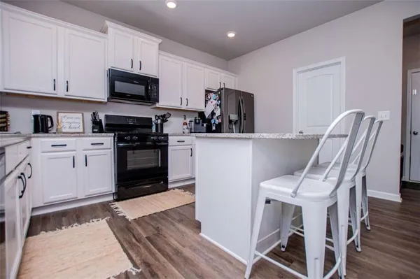 a kitchen with stainless steel appliances granite countertop a sink stove and cabinets