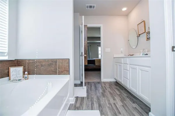 a bathroom with a tub shower vanity and a sink