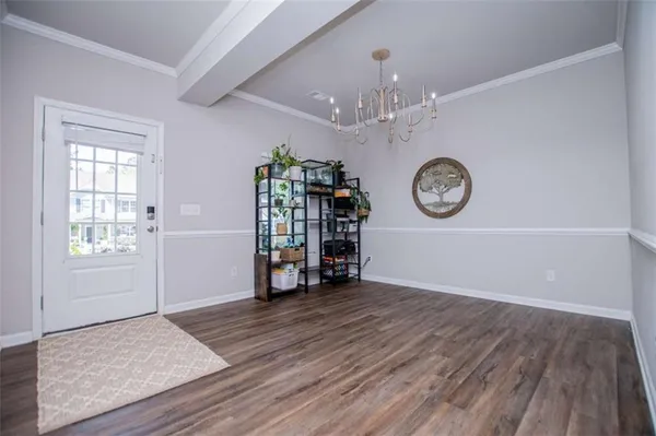 a view of an empty room with window and wooden floor