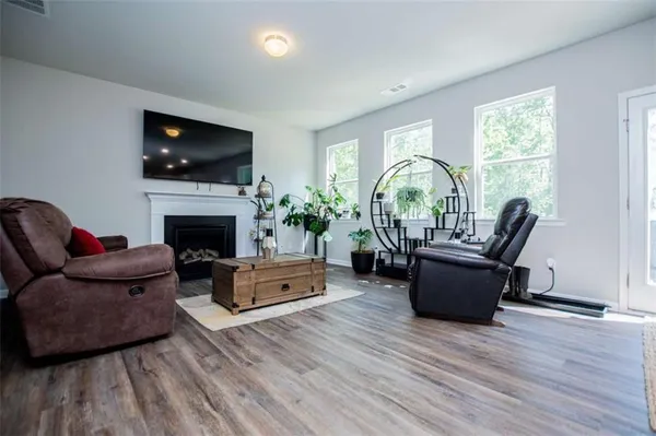 a living room with furniture a flat screen tv and a fireplace
