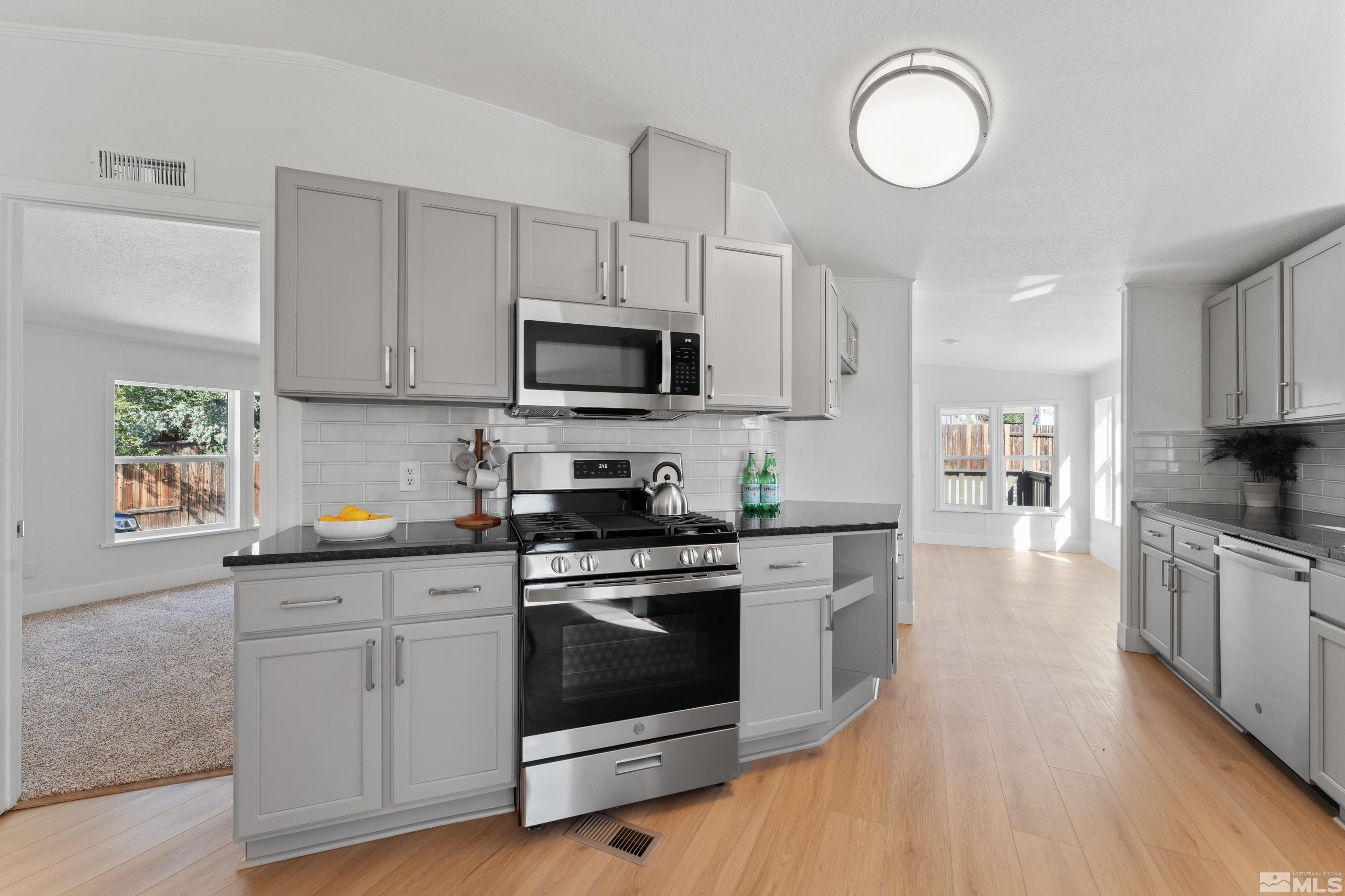 7640 Lytton Road Reno, NV 89506 - Photo 11 of 40 a kitchen with stainless steel appliances white cabinets a sink a stove a refrigerator and microwave