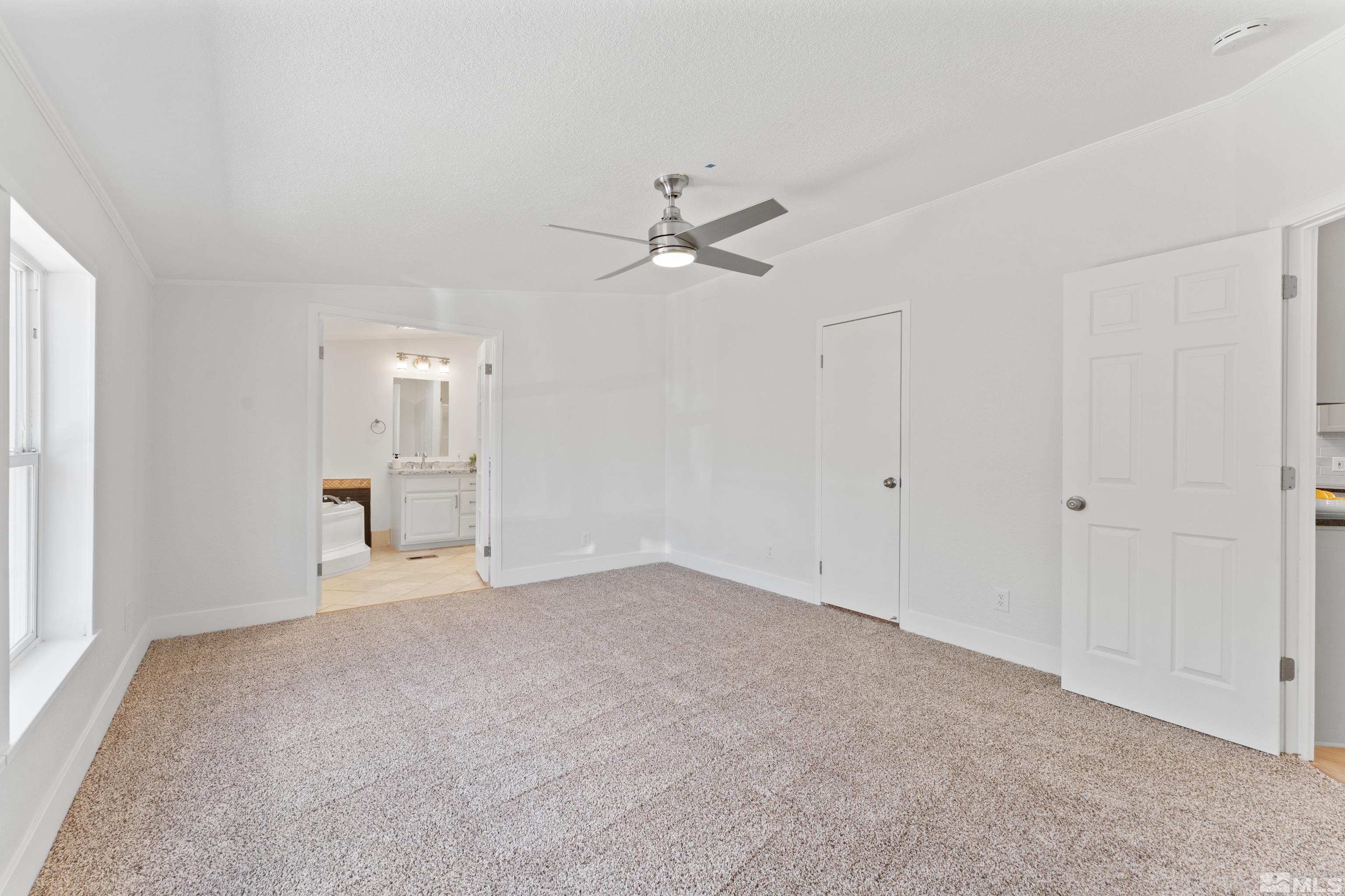 7640 Lytton Road Reno, NV 89506 - Photo 18 of 40 an empty room with chandelier fan and windows