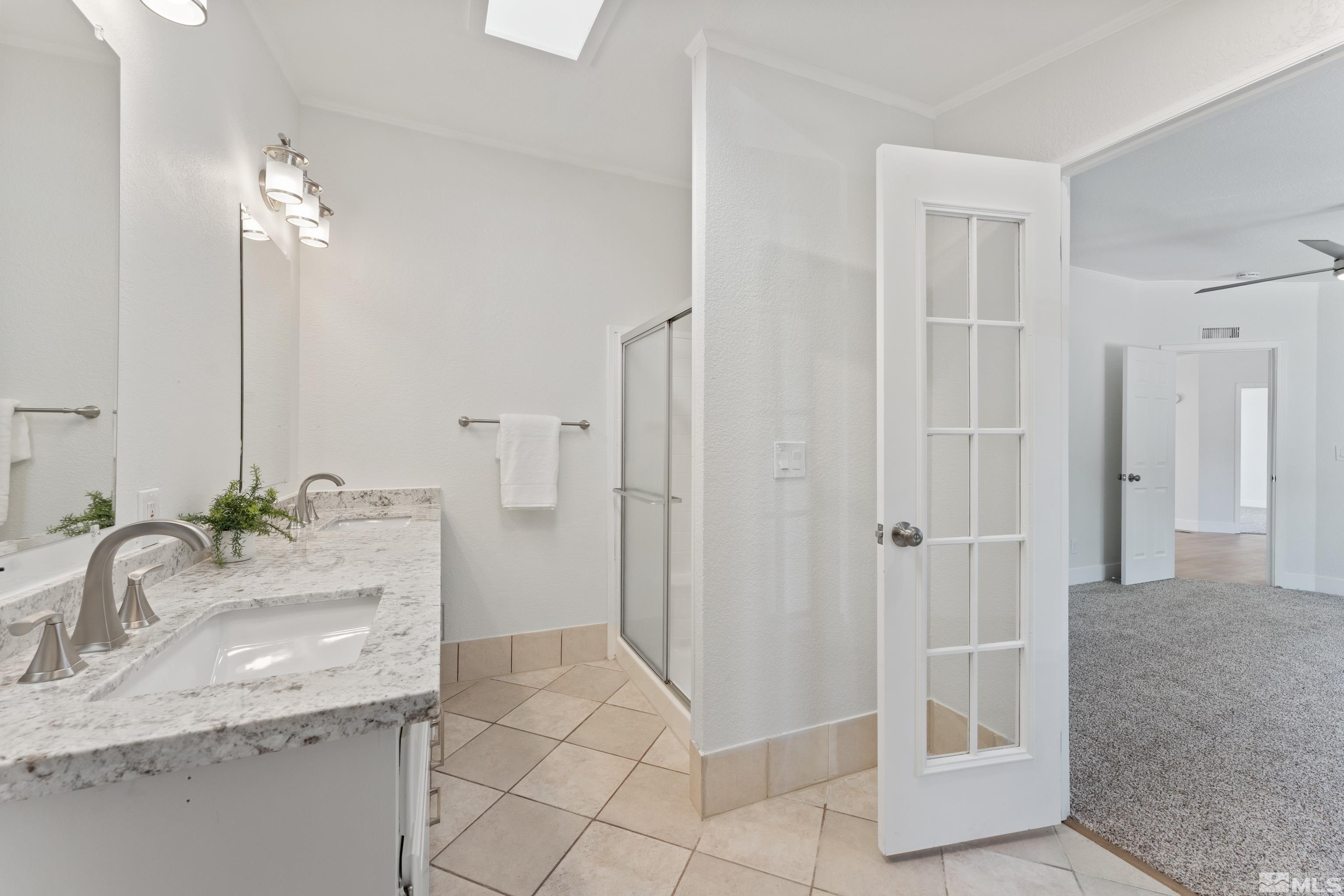 7640 Lytton Road Reno, NV 89506 - Photo 21 of 40 a bathroom with a granite countertop sink a mirror and a shower