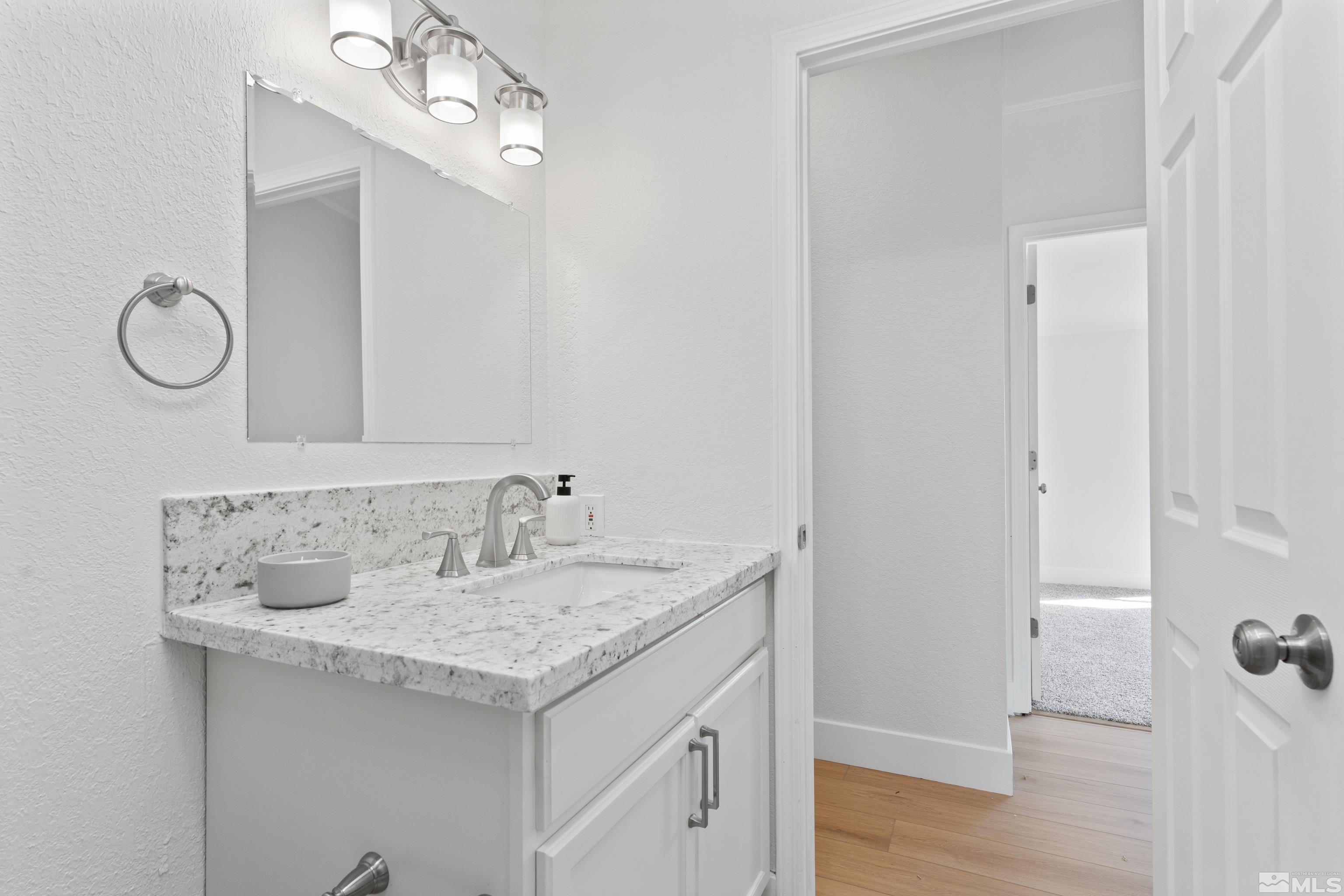 7640 Lytton Road Reno, NV 89506 - Photo 31 of 40 a bathroom with a granite countertop sink and a mirror