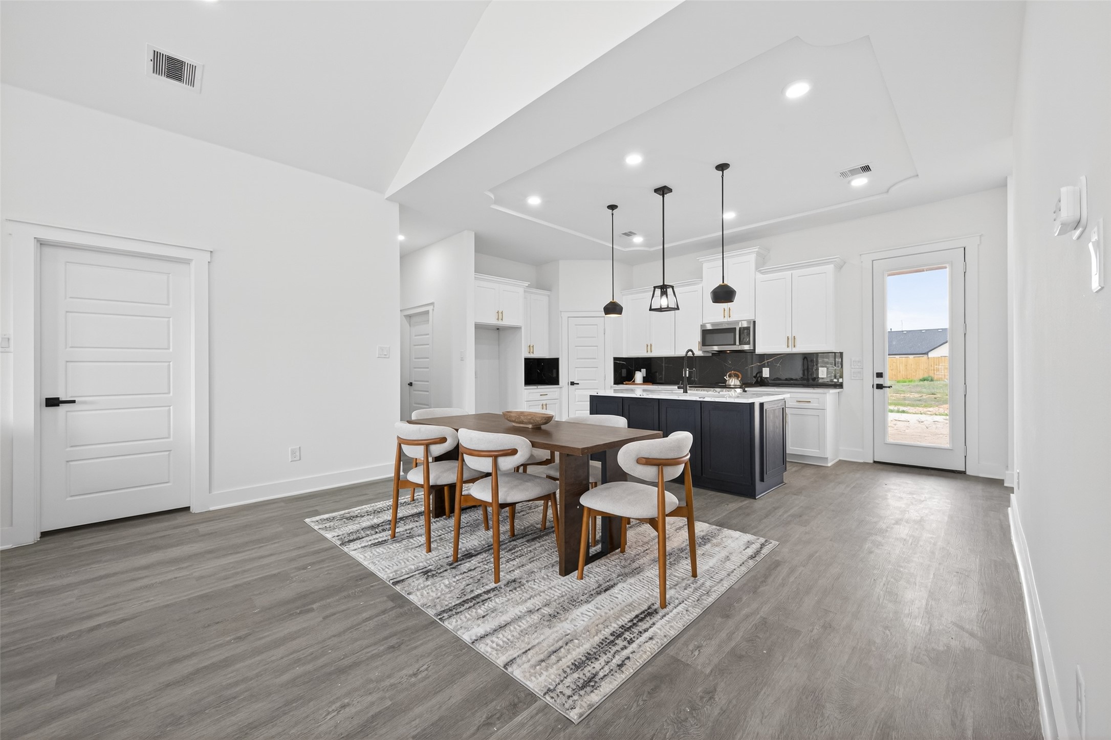 1129 Longleaf Pne Street Huffman, TX 77336 - Photo 13 of 35 a kitchen with stainless steel appliances kitchen island granite countertop wooden floors and white cabinets