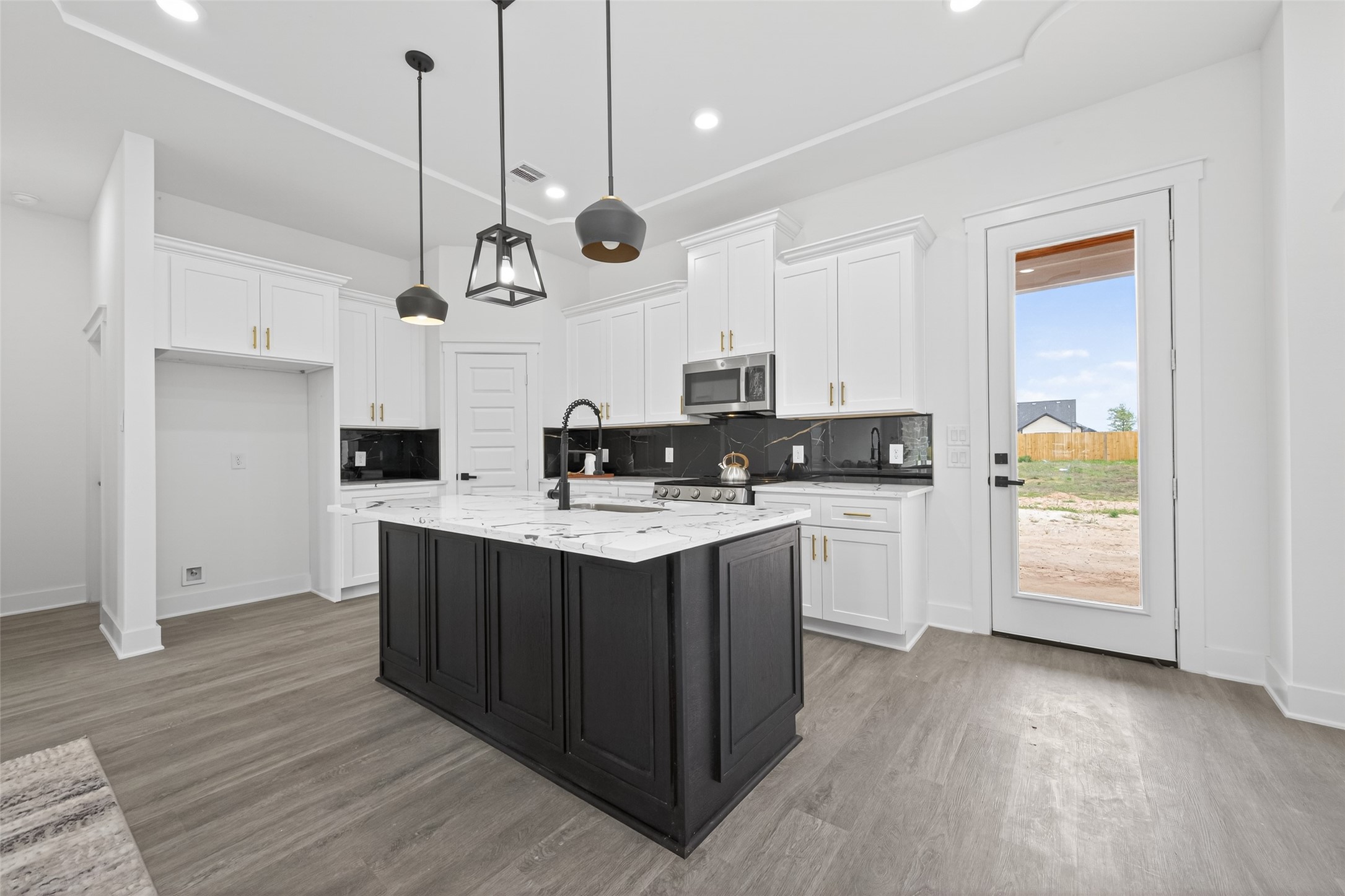 1129 Longleaf Pne Street Huffman, TX 77336 - Photo 7 of 35 a kitchen with stainless steel appliances granite countertop a sink a stove a refrigerator and island with wooden floor