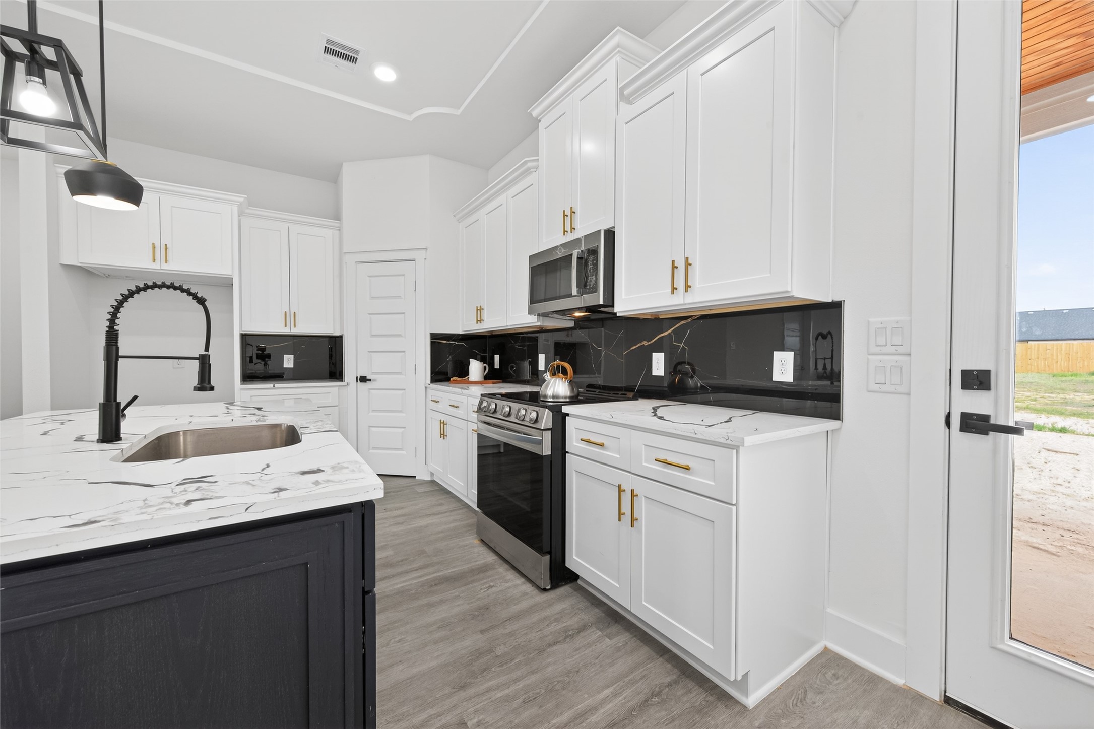1129 Longleaf Pne Street Huffman, TX 77336 - Photo 10 of 35 a kitchen with stainless steel appliances granite countertop a sink a stove top oven a refrigerator with white cabinets and wooden floor
