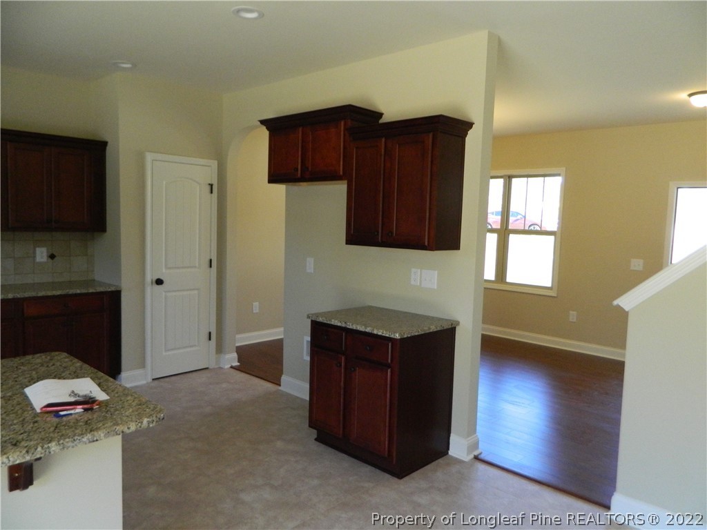 22 Raintree Lane Spring Lake, NC 28390 - Photo 11 of 33 a kitchen with granite countertop a stove and a wooden cabinets