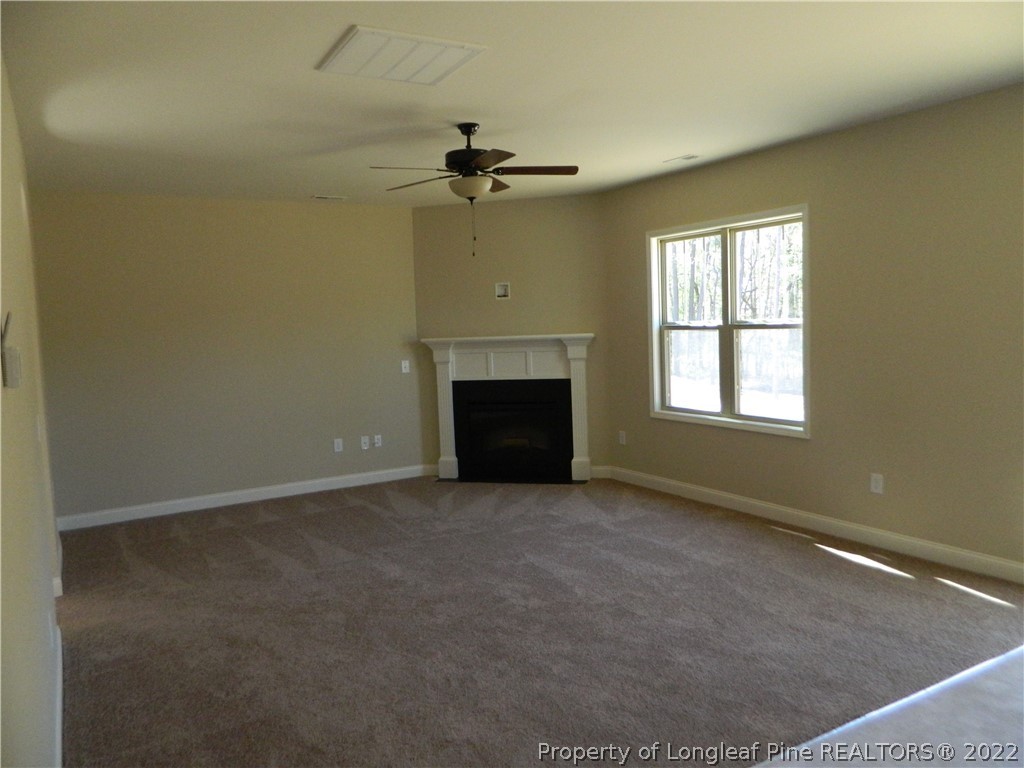 22 Raintree Lane Spring Lake, NC 28390 - Photo 9 of 33 an empty room with windows fireplace and fan