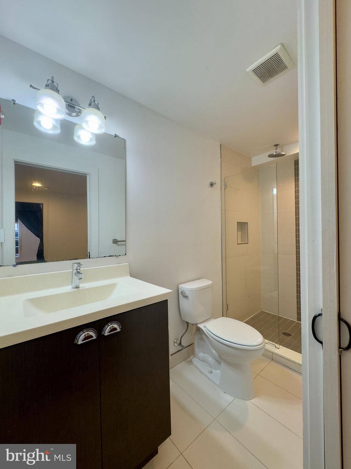 613 Portland Street, Unit 11 Baltimore, MD 21230 - Photo 8 of 9 a bathroom with a sink a toilet a mirror and shower