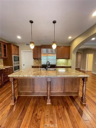 a kitchen with stainless steel appliances granite countertop a stove and a wooden floors