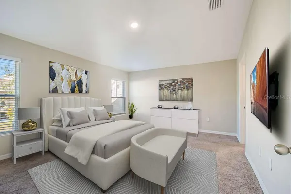 a spacious bedroom with a bed a couch and a window