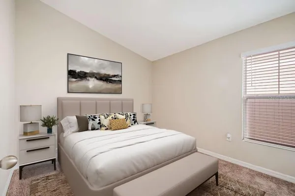 a bedroom with a bed and a painting on the wall