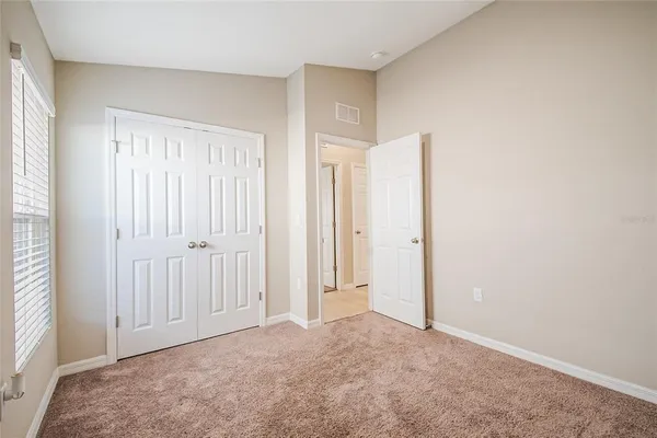 an empty room with windows and closet