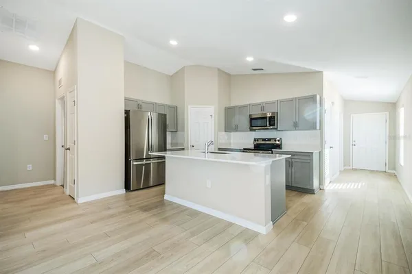 a kitchen with white cabinets and stainless steel appliances