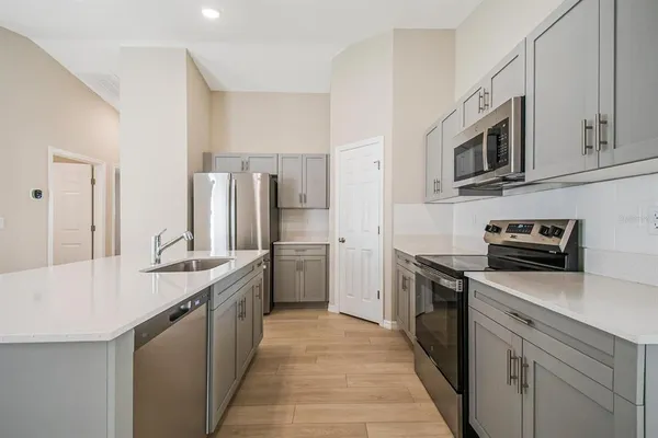 a kitchen with stainless steel appliances a sink stove top oven and refrigerator
