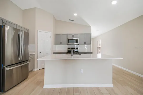 a kitchen with stainless steel appliances a refrigerator and a stove top oven