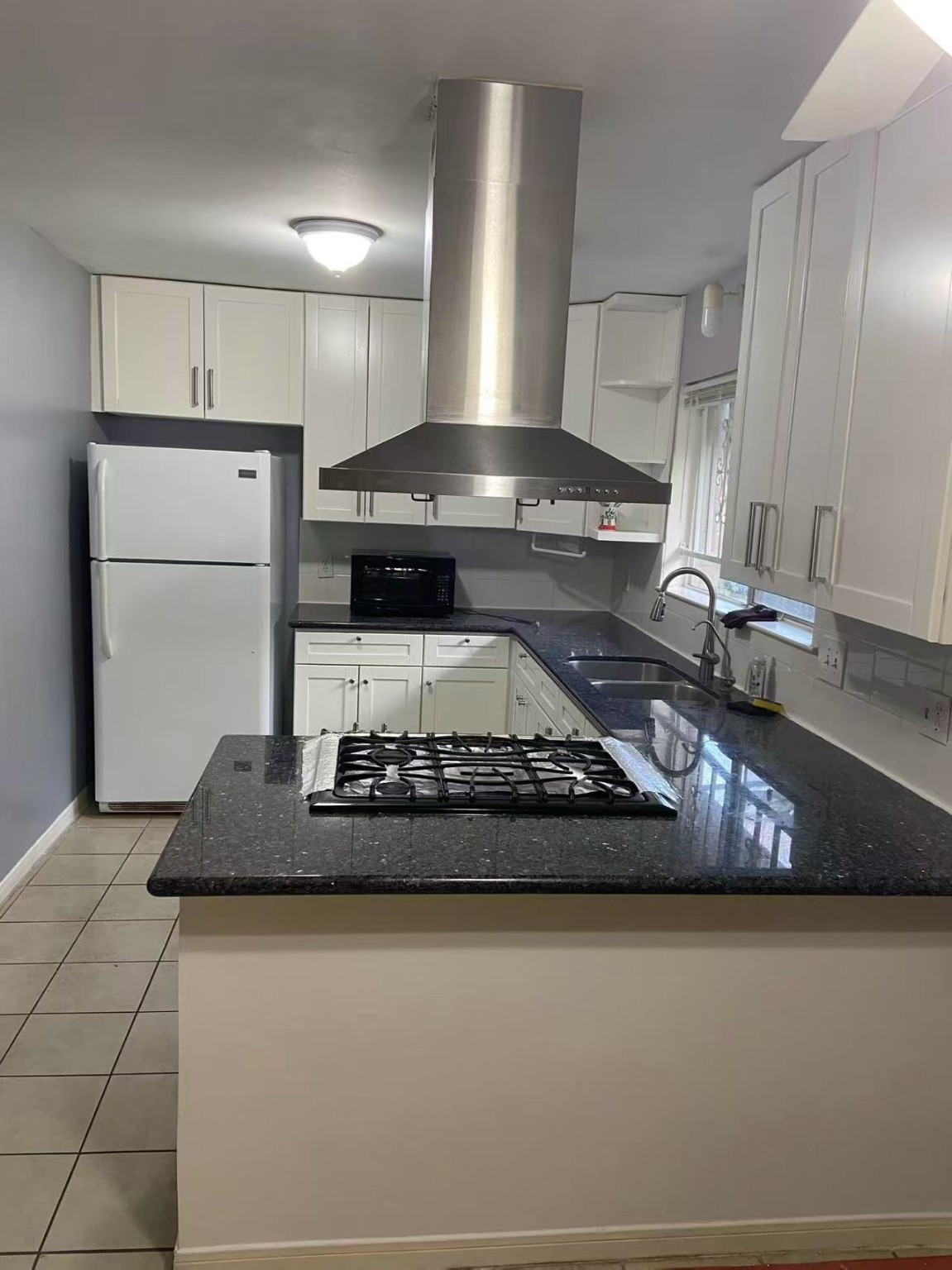 a kitchen with kitchen island granite countertop stainless steel appliances a sink stove and refrigerator