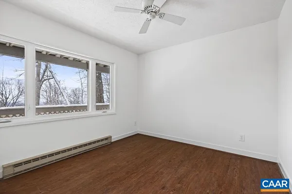 an empty room with wooden floor and window