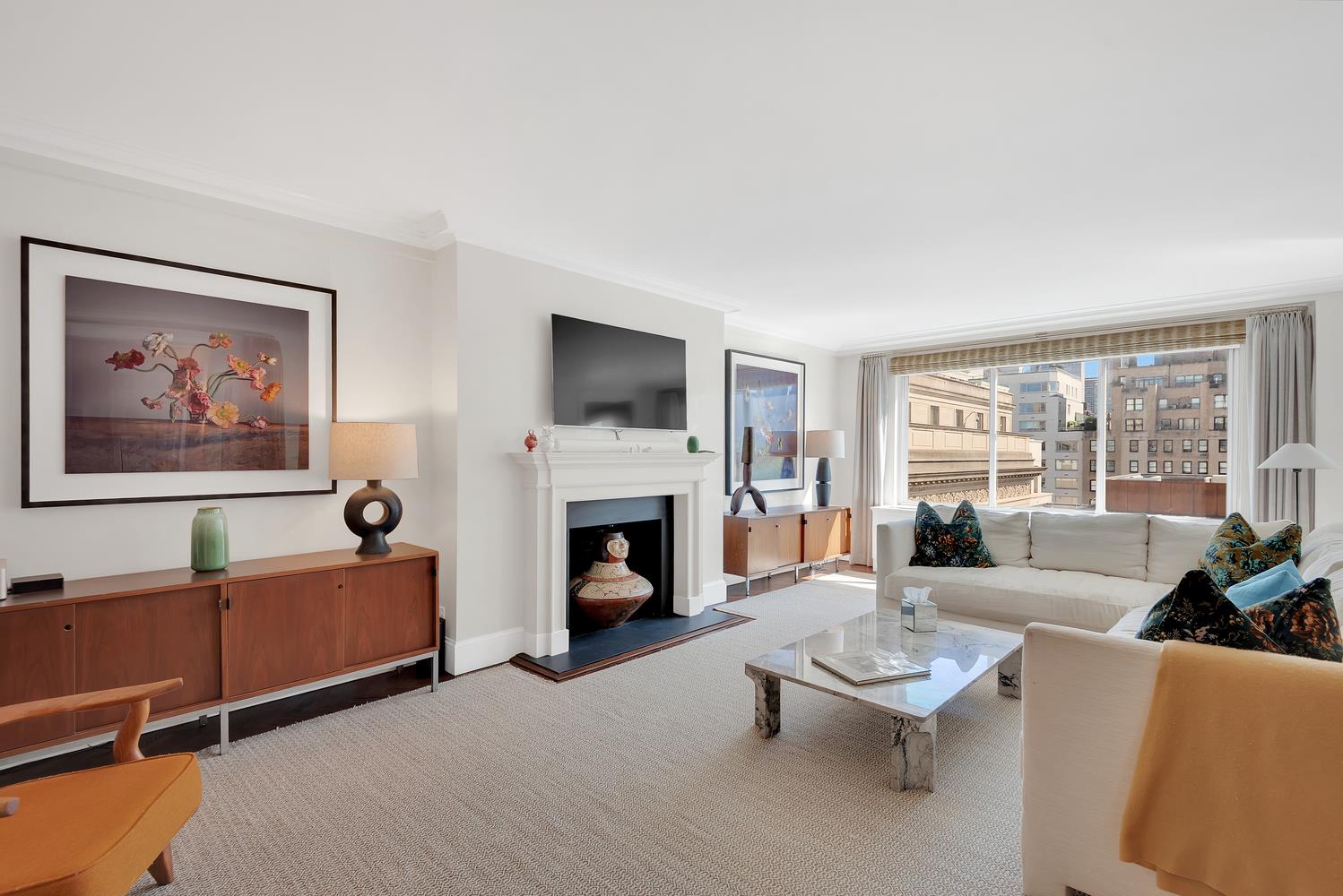 3 East 71st Street, Unit 10/11B Manhattan, NY 10021 - Photo 2 of 17 a living room with furniture a fireplace and a flat screen tv