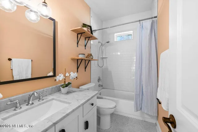 a bathroom with a granite countertop sink a toilet and a mirror