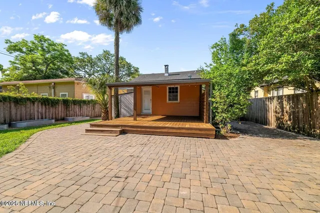 a view of a house with backyard and tree