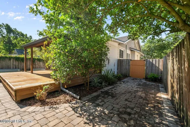 a view of a patio with table and chairs and wooden fence