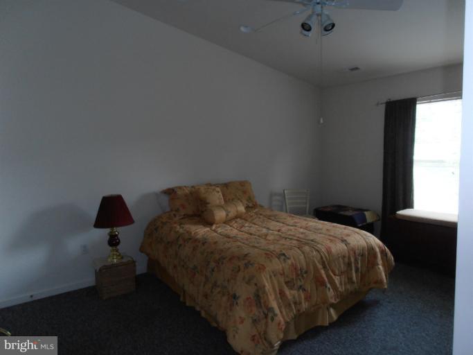 3065 Cox Road Chesapeake Beach, MD 20732 - Photo 15 of 17 a bedroom with a bed lamp and window