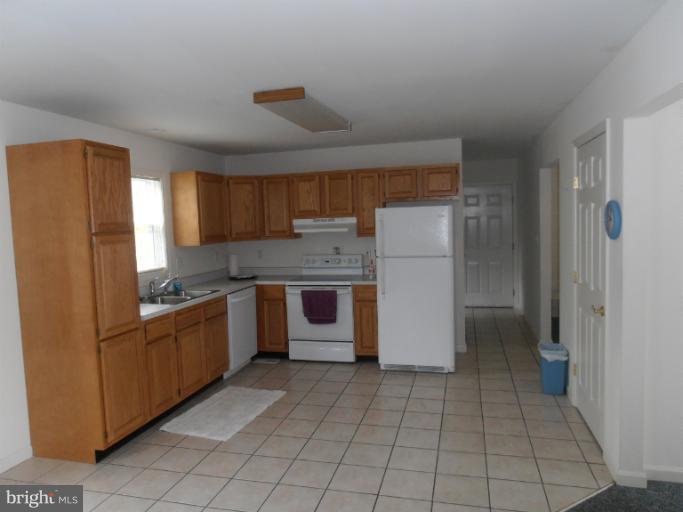 3065 Cox Road Chesapeake Beach, MD 20732 - Photo 4 of 17 a kitchen with a refrigerator sink and cabinets