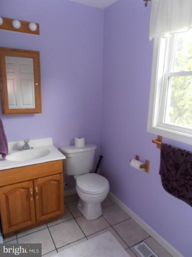 3065 Cox Road Chesapeake Beach, MD 20732 - Photo 6 of 17 a bathroom with a granite countertop toilet a sink and a window