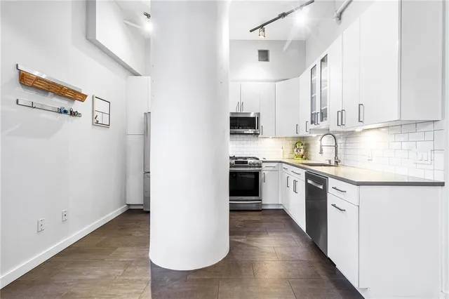 a kitchen with a sink cabinets stainless steel appliances and a window