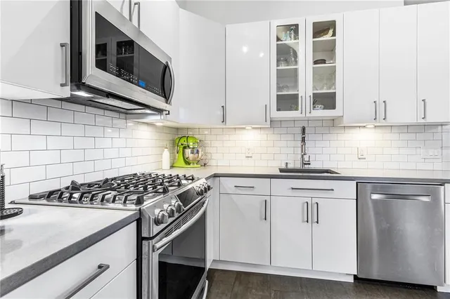 a kitchen with stainless steel appliances granite countertop a sink stove and cabinets