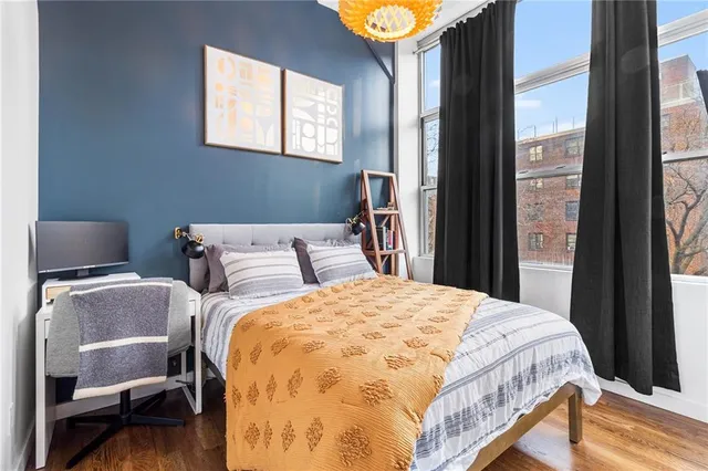 a bed sitting in a bedroom next to a window