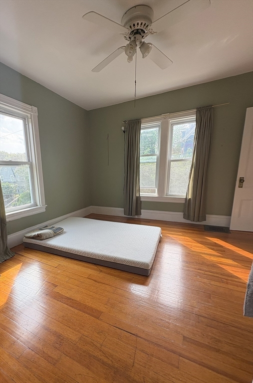 21 Conway Street, Unit 2 Boston, MA 02131 - Photo 8 of 12 an empty room with wooden floor and windows