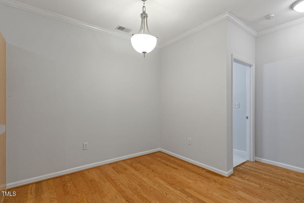 800 Moratuck Drive, Unit 102 Raleigh, NC 27604 - Photo 16 of 36 a view of an empty room with wooden floor and a window