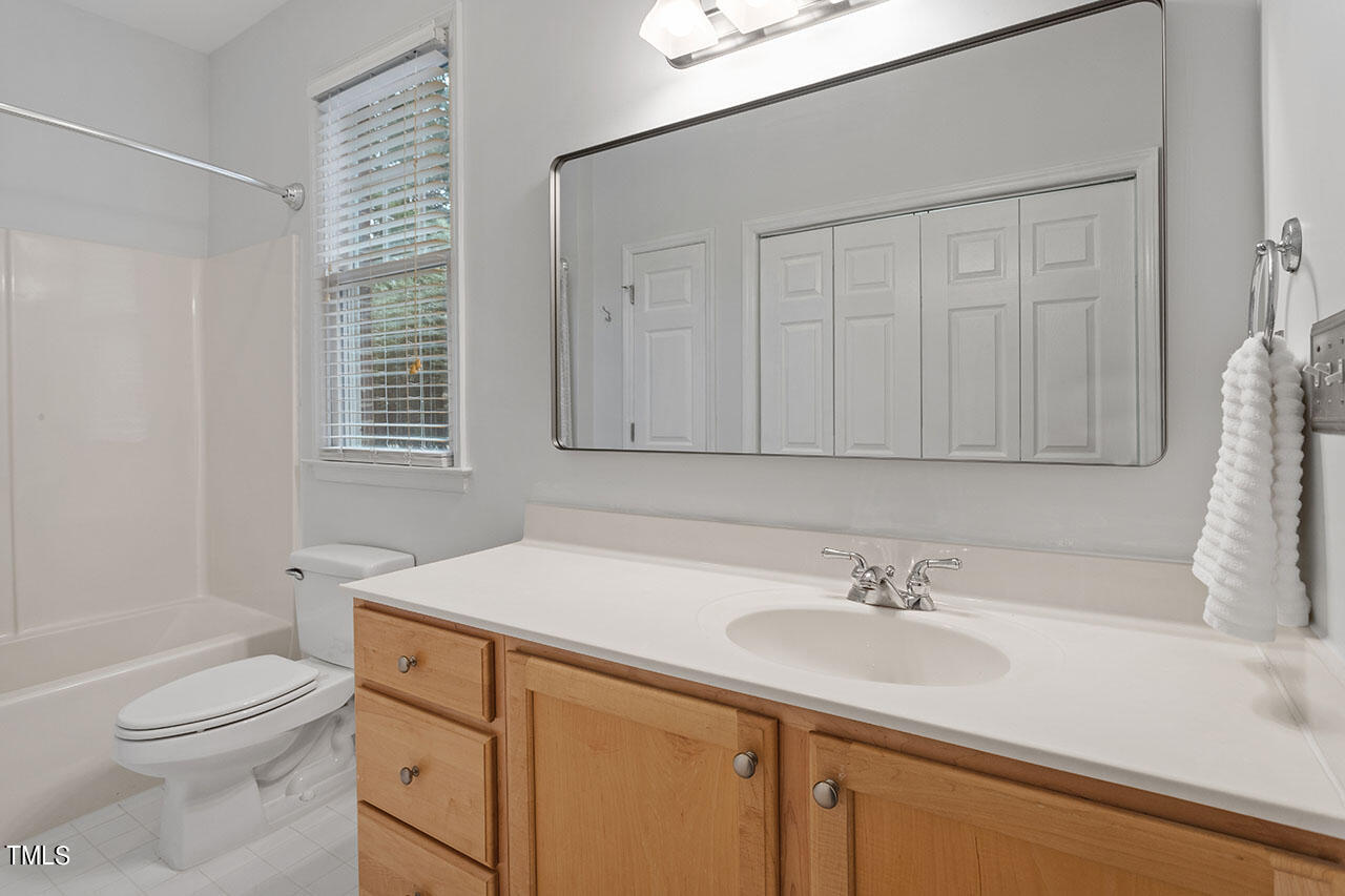 800 Moratuck Drive, Unit 102 Raleigh, NC 27604 - Photo 24 of 36 a bathroom with a sink toilet a vanity and shower