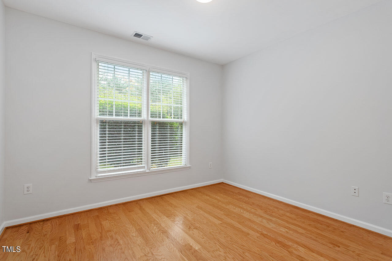 800 Moratuck Drive, Unit 102 Raleigh, NC 27604 - Photo 25 of 36 a view of an empty room with wooden floor and a window