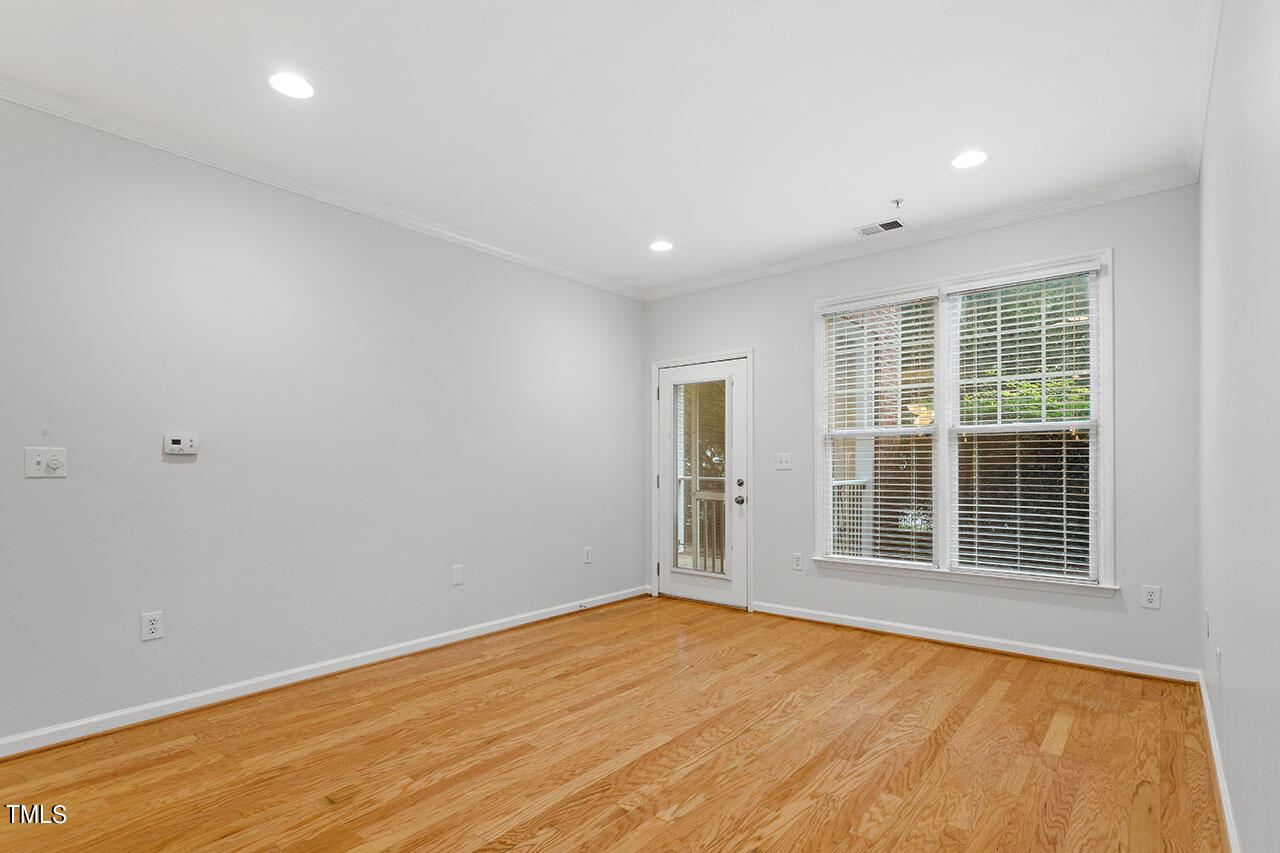 800 Moratuck Drive, Unit 102 Raleigh, NC 27604 - Photo 5 of 36 an empty room with wooden floor and windows