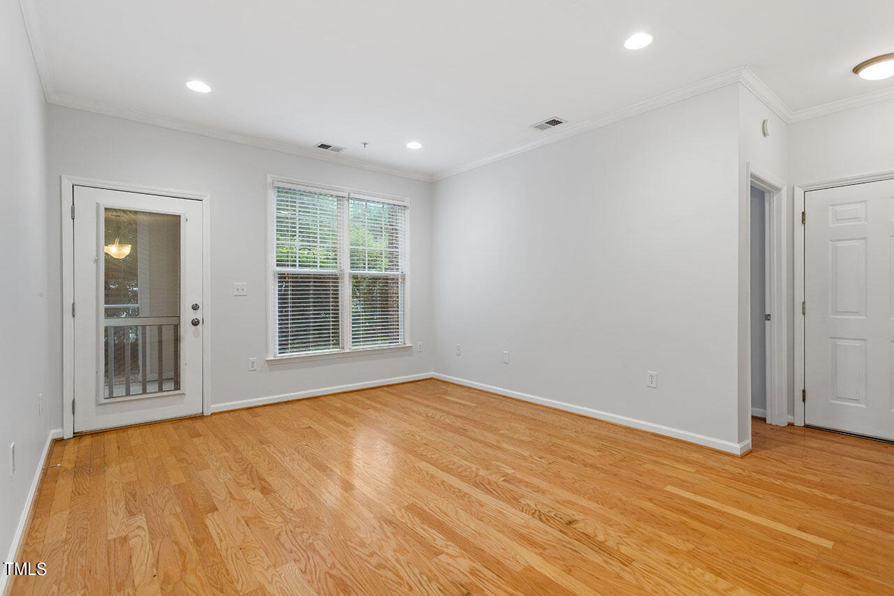 800 Moratuck Drive, Unit 102 Raleigh, NC 27604 - Photo 8 of 36 a view of an empty room with wooden floor and a window