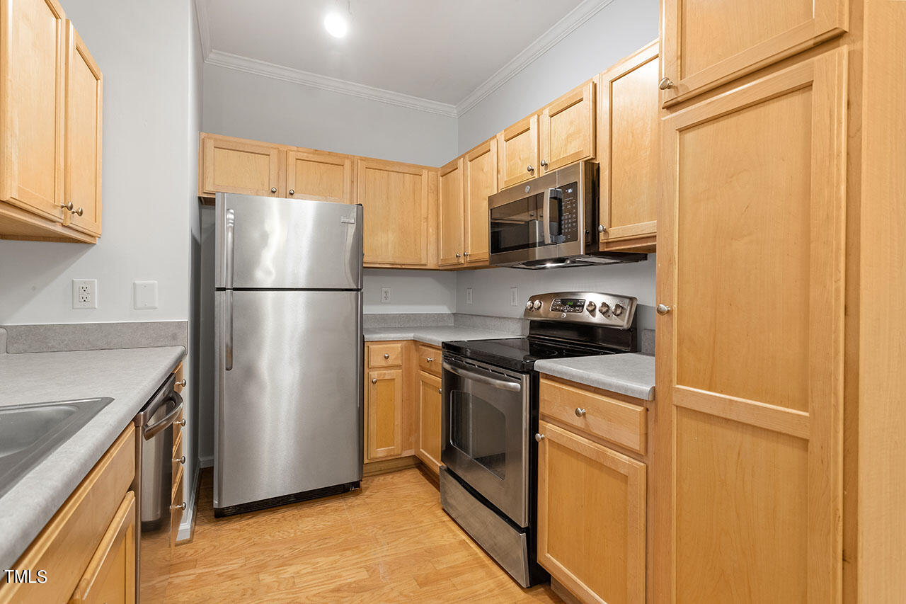 800 Moratuck Drive, Unit 102 Raleigh, NC 27604 - Photo 10 of 36 a kitchen with stainless steel appliances a refrigerator a stove a microwave a sink and cabinets