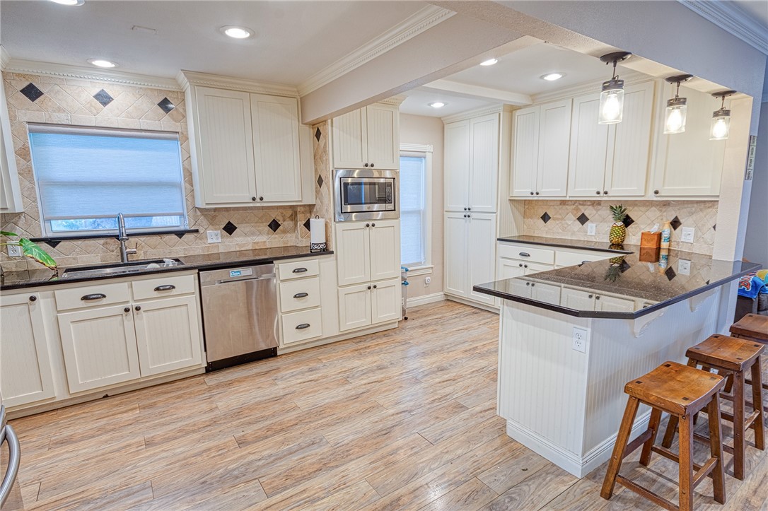 1202 Crosby Street Portland, TX 78374 - Photo 9 of 20 a kitchen with granite countertop a sink cabinets and wooden floor