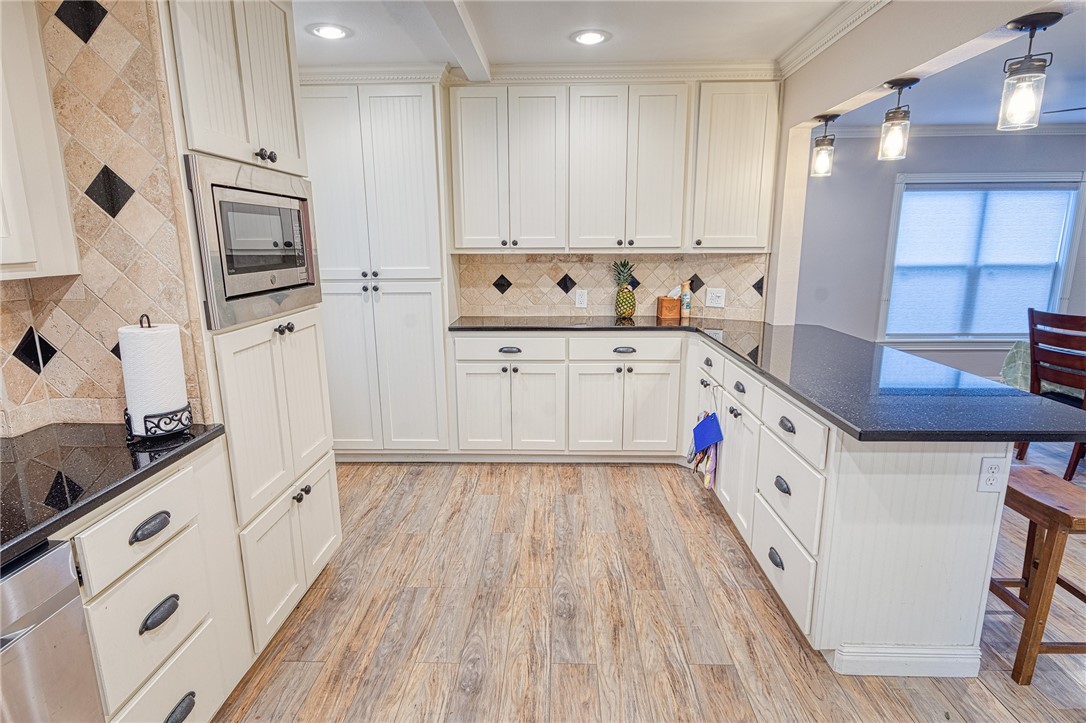 1202 Crosby Street Portland, TX 78374 - Photo 10 of 20 a kitchen with stainless steel appliances white cabinets and wooden floors
