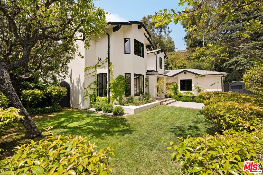 9872 Whitwell Drive Beverly Hills, CA 90210 - Photo 2 of 32 a view of a white house with a big yard and large trees