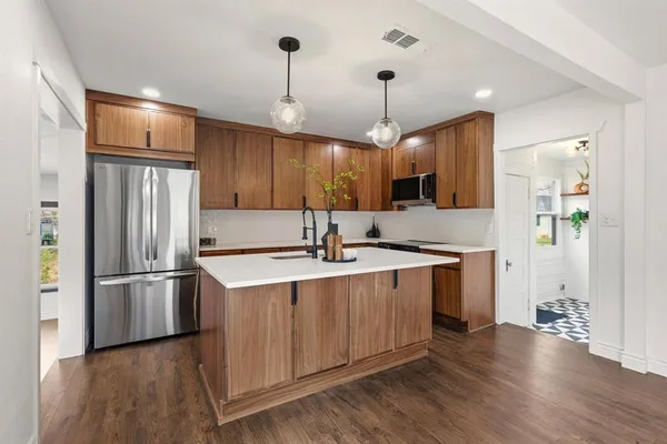 a kitchen with kitchen island a sink appliances and cabinets