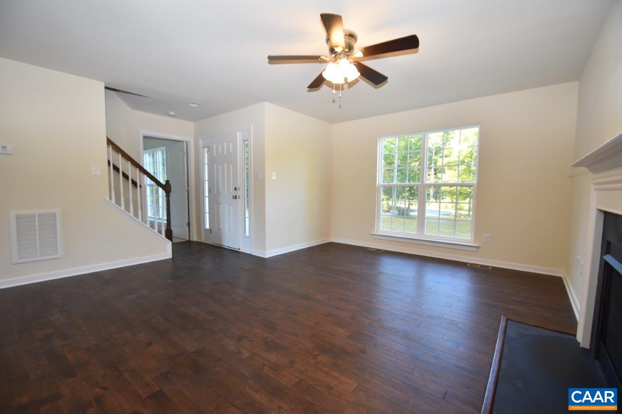87 Riva Way Palmyra, VA 22963 - Photo 9 of 19 an empty room with wooden floor chandelier fan and windows