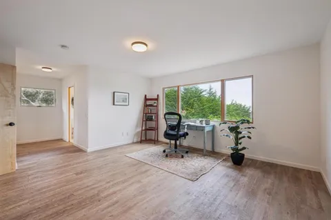 a view of a workspace with furniture and a floor to ceiling window
